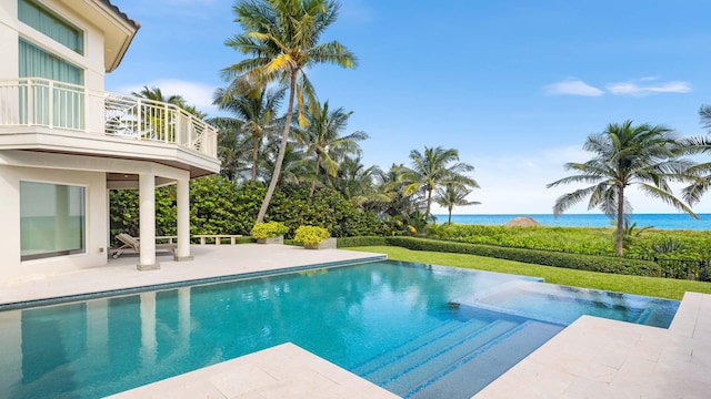 view of pool featuring a yard, a patio, and a water view