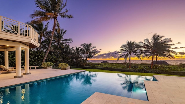 pool at dusk featuring a patio area