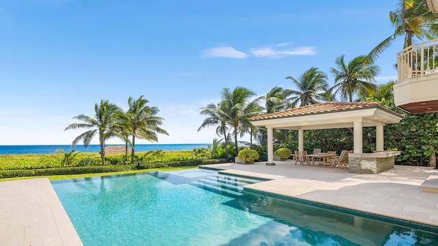 view of swimming pool featuring a patio, a water view, a gazebo, and a jacuzzi