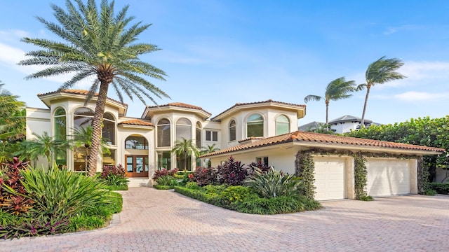 mediterranean / spanish home with french doors and a garage