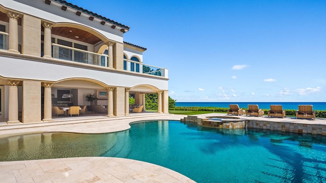 view of swimming pool with a water view, an in ground hot tub, and a patio