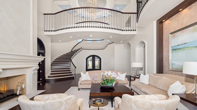 living room with hardwood / wood-style floors, a towering ceiling, french doors, and an inviting chandelier