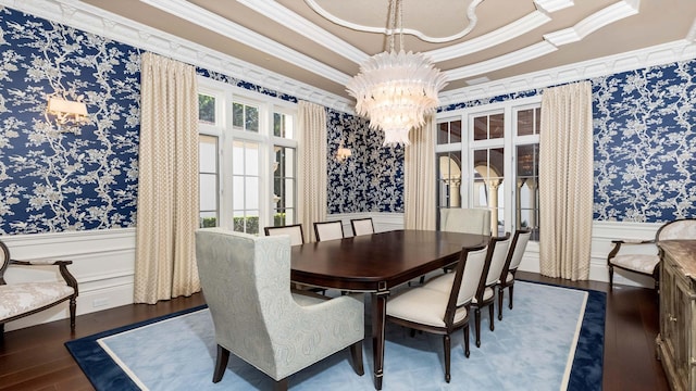 dining space featuring a chandelier, ornamental molding, a raised ceiling, and dark wood-type flooring