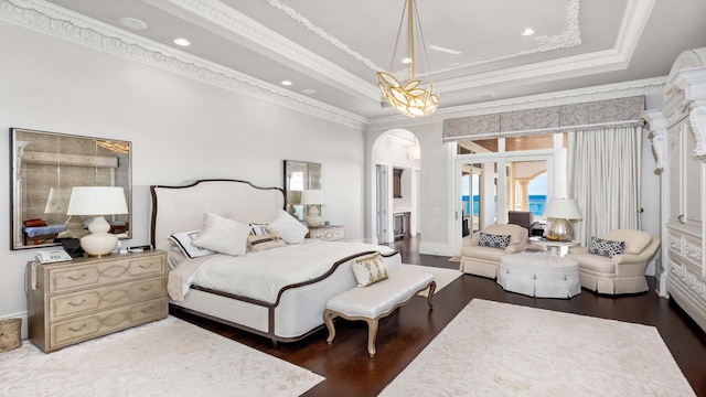 bedroom featuring dark hardwood / wood-style flooring, a tray ceiling, and crown molding