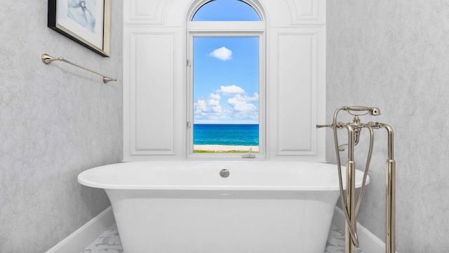 bathroom with a washtub and a water view