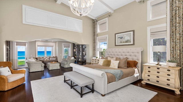 bedroom featuring dark wood-type flooring, a high ceiling, and a notable chandelier