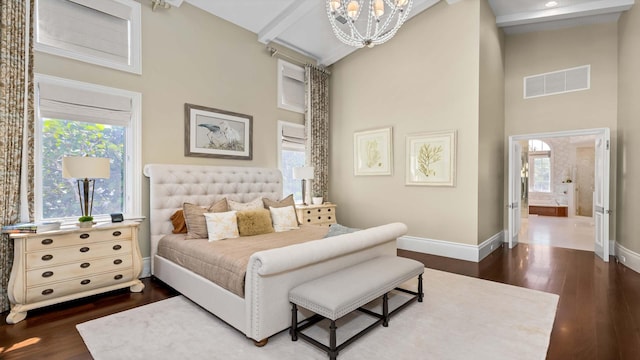 bedroom with multiple windows, ensuite bathroom, dark hardwood / wood-style flooring, and high vaulted ceiling