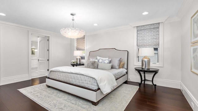 bedroom with a notable chandelier, dark hardwood / wood-style floors, ornamental molding, and ensuite bathroom