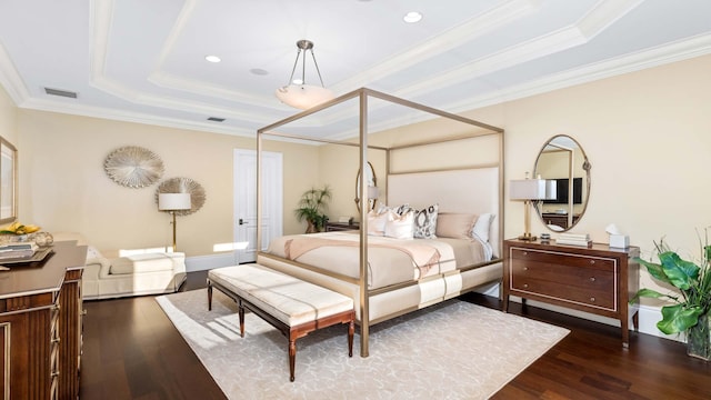 bedroom with dark hardwood / wood-style floors, ornamental molding, and a tray ceiling