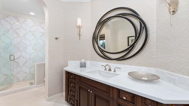 bathroom featuring tile patterned floors, vanity, a shower with door, and crown molding