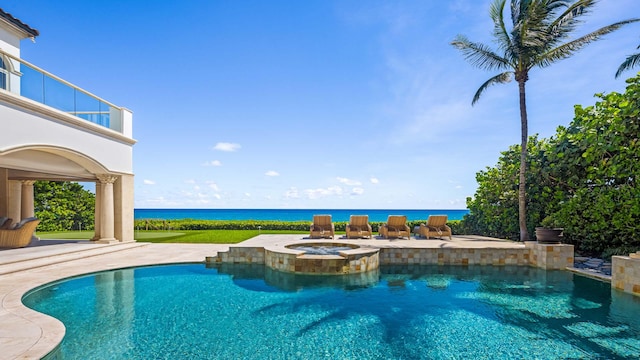 view of swimming pool featuring a patio area, a water view, and an in ground hot tub