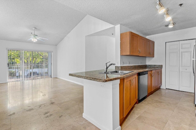 kitchen with stainless steel dishwasher, kitchen peninsula, sink, and a textured ceiling