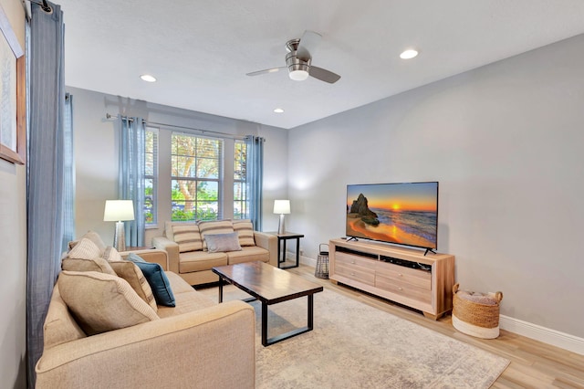 living room with ceiling fan and light hardwood / wood-style flooring