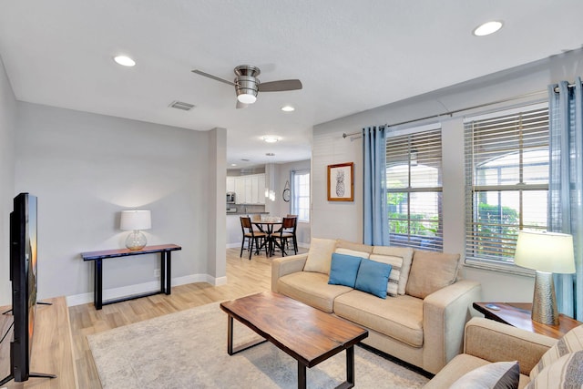 living room with ceiling fan and light hardwood / wood-style flooring