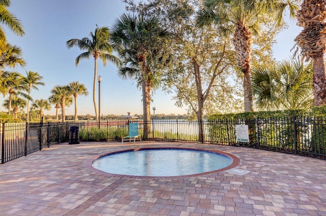 pool at dusk with a patio area