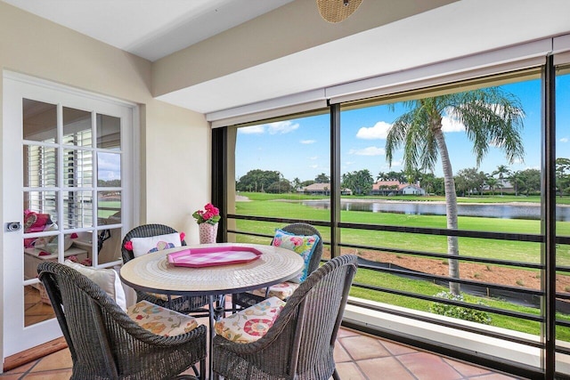 sunroom featuring a water view