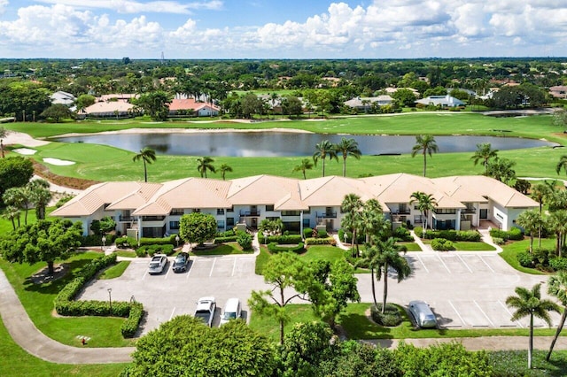 drone / aerial view with view of golf course and a water view