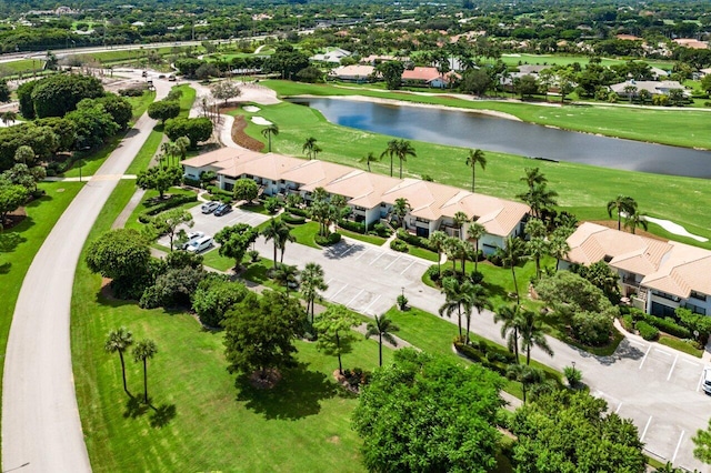drone / aerial view featuring a residential view, view of golf course, and a water view
