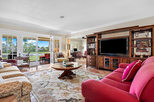 living room featuring light tile patterned flooring, ceiling fan, french doors, ornamental molding, and a textured ceiling