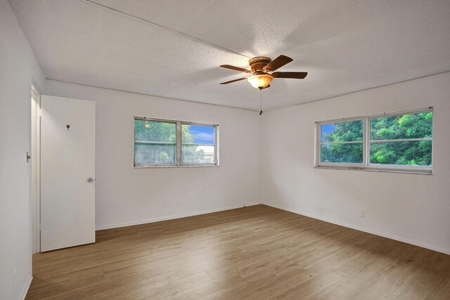 spare room with ceiling fan, a textured ceiling, and hardwood / wood-style floors