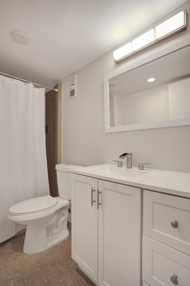 bathroom with toilet, walk in shower, and vanity