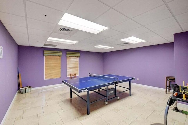 rec room with a paneled ceiling and light tile patterned floors