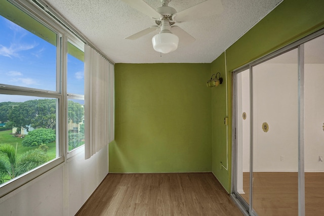 unfurnished sunroom with ceiling fan