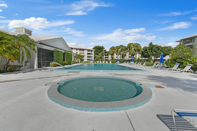 view of swimming pool with a community hot tub and a patio