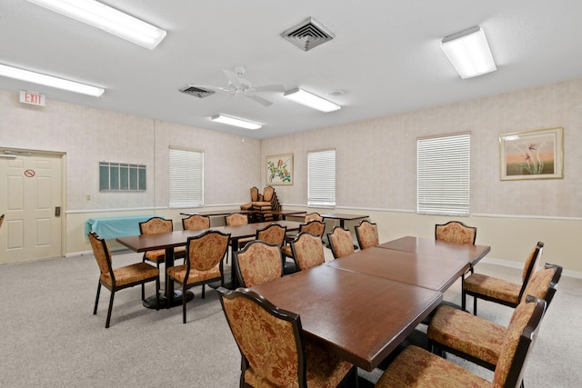 carpeted dining room with ceiling fan