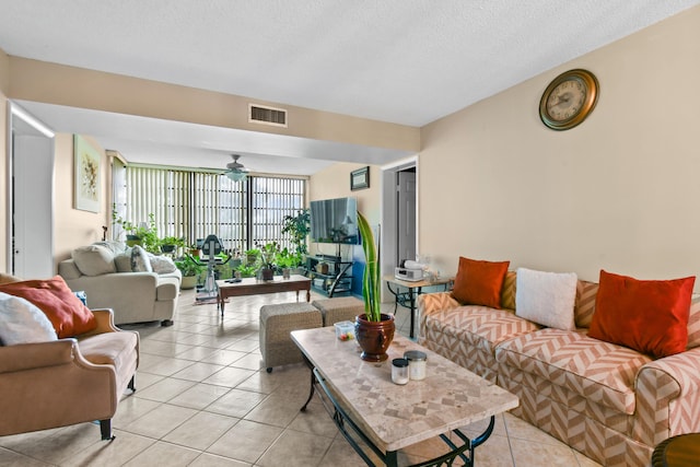 living room featuring ceiling fan, light tile patterned flooring, a textured ceiling, and a wall of windows