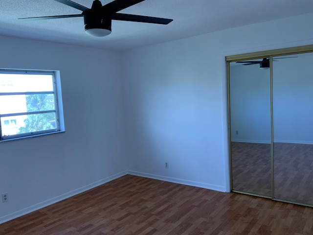 unfurnished bedroom with ceiling fan, a closet, a textured ceiling, and hardwood / wood-style flooring