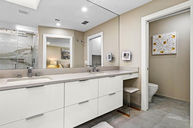 bathroom featuring toilet, vanity, and an enclosed shower