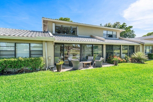 rear view of house with a patio, a yard, and a sunroom