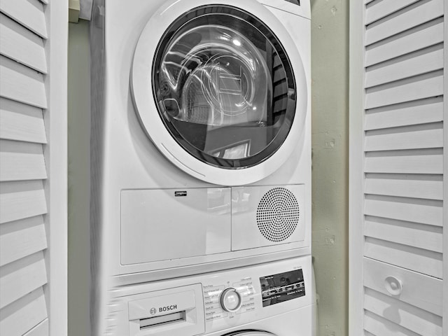 washroom featuring stacked washer / drying machine