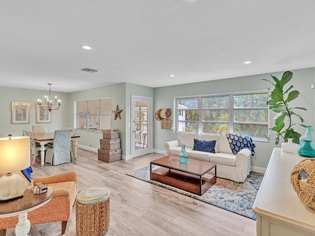 living room featuring a notable chandelier and light wood-type flooring