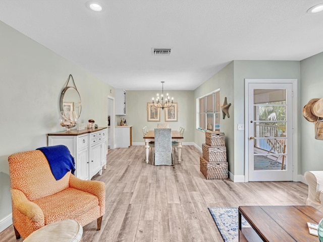 sitting room featuring a chandelier and light hardwood / wood-style flooring