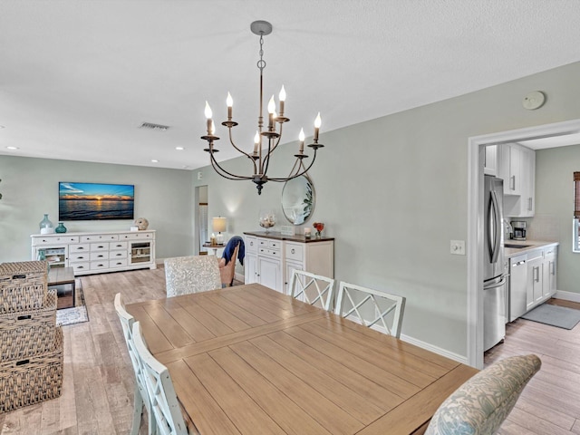 dining area featuring a notable chandelier and light hardwood / wood-style flooring