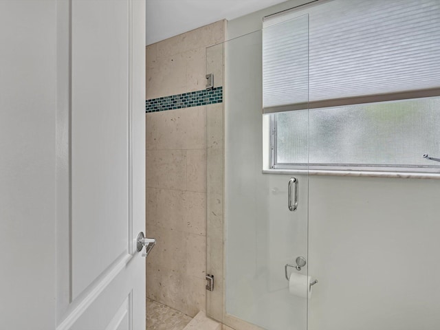 bathroom with a shower with door