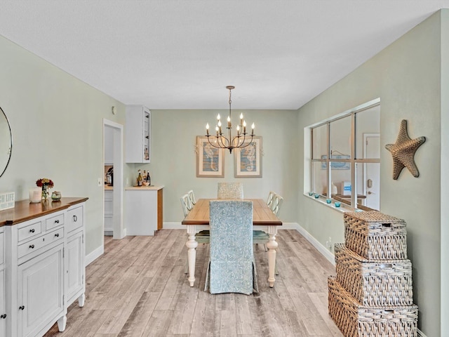 dining area featuring an inviting chandelier and light hardwood / wood-style flooring