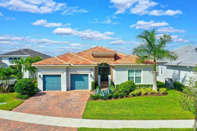 mediterranean / spanish-style house featuring central AC, a front lawn, and a garage