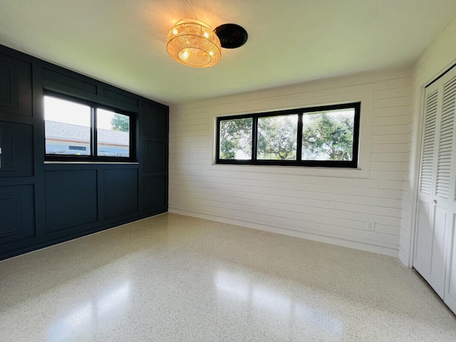 unfurnished bedroom featuring a chandelier and a closet