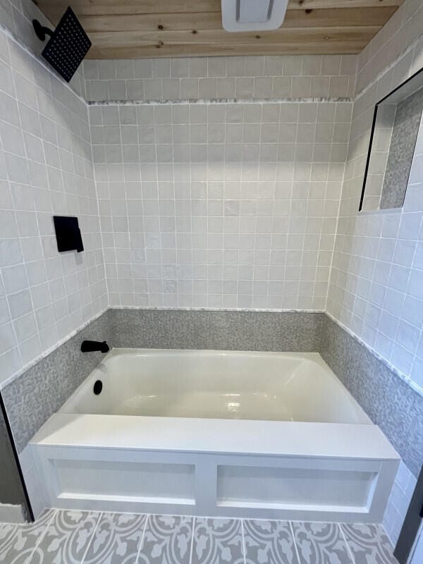 bathroom with tiled shower / bath and wood ceiling