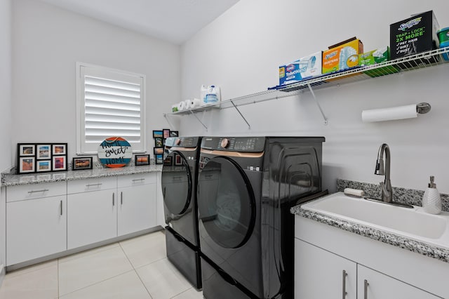 washroom featuring independent washer and dryer, cabinets, sink, and light tile patterned floors