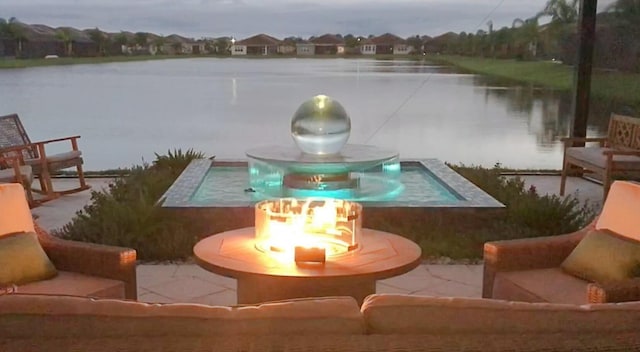 view of dock with a patio area, a swimming pool with hot tub, and a water view