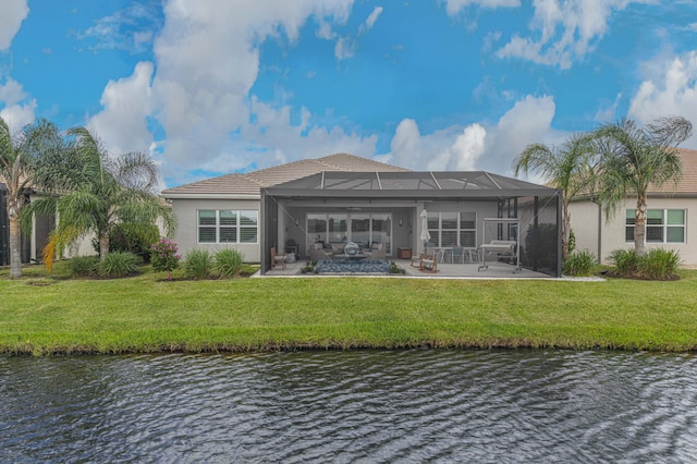 back of property with a patio, a water view, a lawn, and glass enclosure