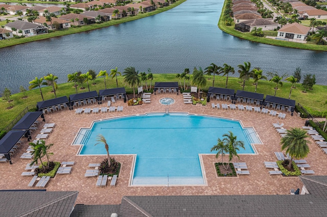 view of swimming pool featuring a patio and a water view