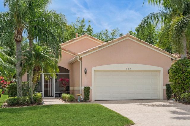 mediterranean / spanish-style house featuring a garage and a front lawn