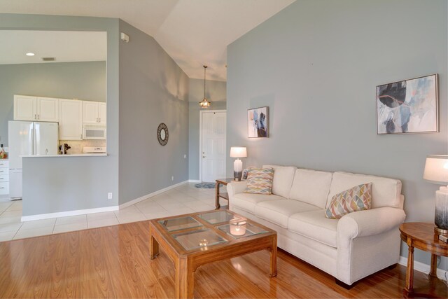 living room with lofted ceiling and light hardwood / wood-style flooring