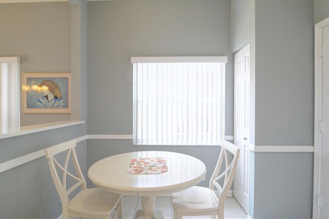 dining space with vaulted ceiling with beams, an inviting chandelier, and light tile patterned floors