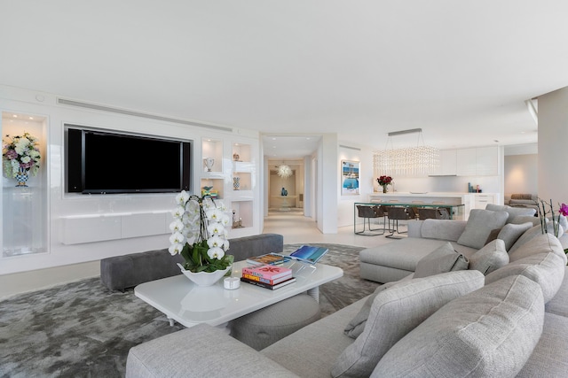 carpeted living room with a notable chandelier